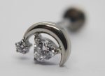 Silver crescent-shaped stud earring featuring a large round faceted clear gemstone and a smaller prong-set crystal on a white background.