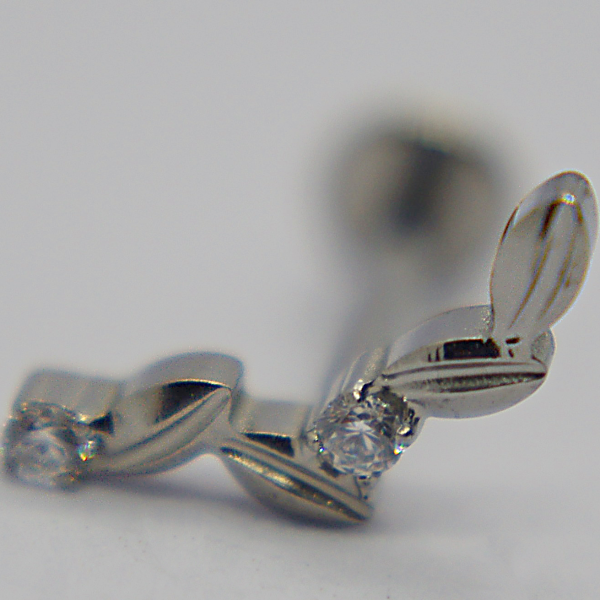 Close-up of a silver leaf-shaped earring stud set with two small round clear gemstones on a white background.