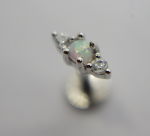 Small silver stud earring with a round opal center flanked by two clear gemstones on a gray background.