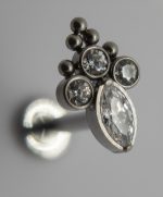 Close-up of a silver stud earring with three small round crystals and a larger marquise-cut crystal in a clustered setting.