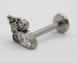 Silver labret-style earring with a large pear-shaped clear gemstone, three small round bezel-set crystals, and three tiny metal beads on white background
