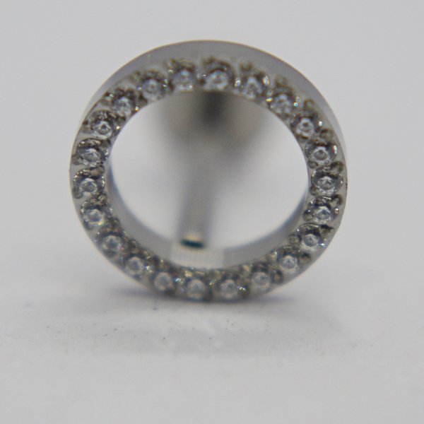 Silver hollow circular earring stud encrusted with small clear gemstones around the rim, shown front-on on a white background.