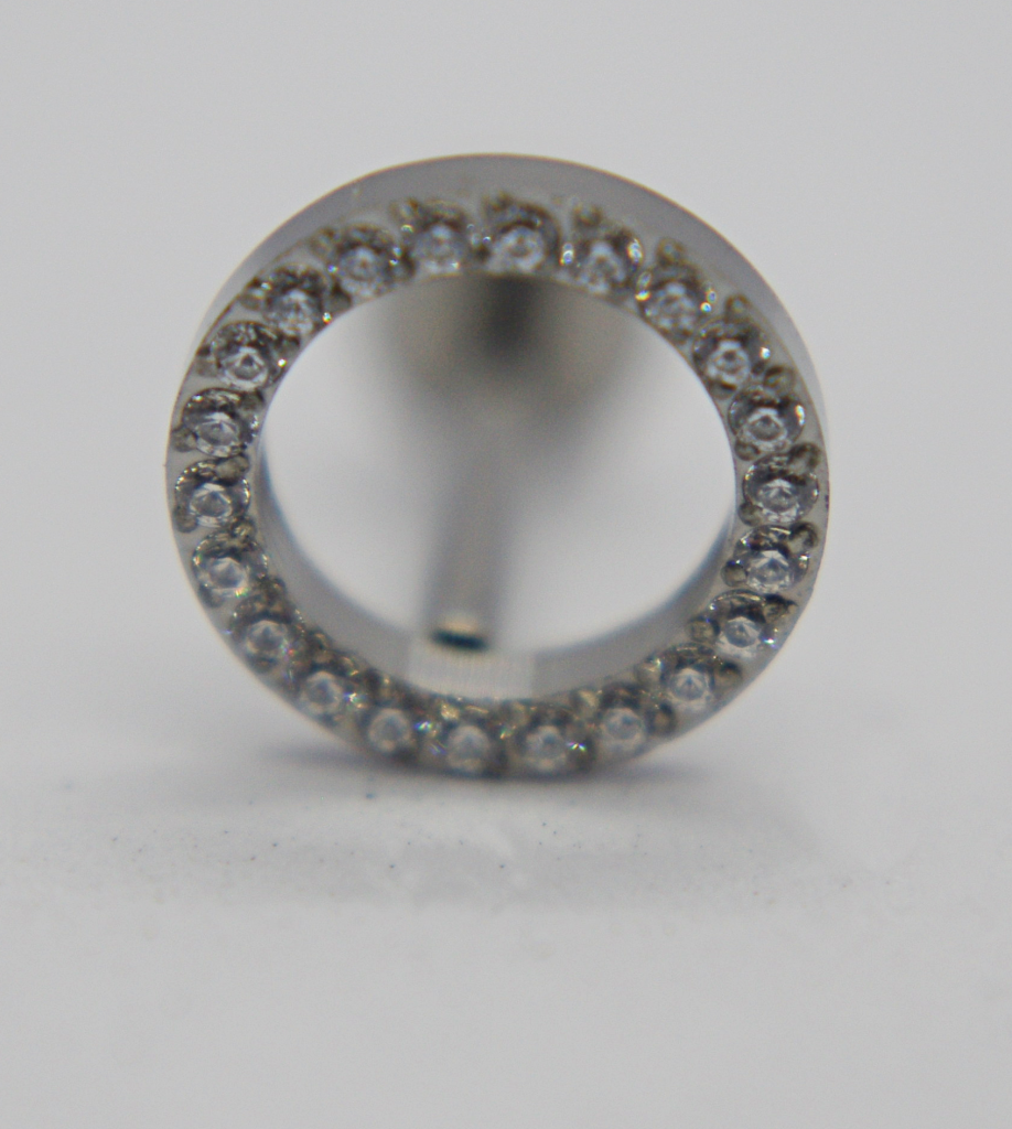 Silver hollow circular earring stud encrusted with small clear gemstones around the rim, shown front-on on a white background.