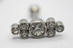 Silver jewelry stud with one large faceted central crystal surrounded by six smaller round crystals on a white background.