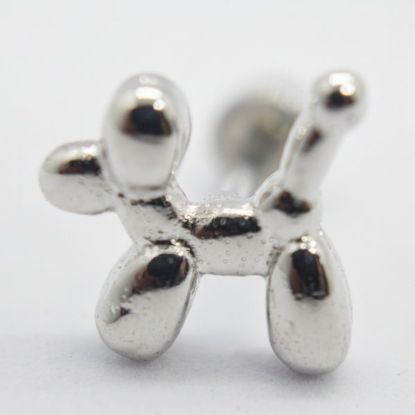 Close-up of a small shiny silver balloon-dog shaped metal stud on a white background.