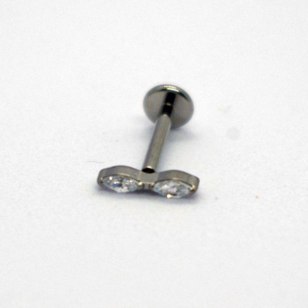 Silver metal labret/piercing stud with a horizontal double-clear gemstone bar resting on a white background.