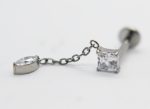 Silver chain earring with a square-cut clear gemstone and a small marquise-cut stone resting on a white surface