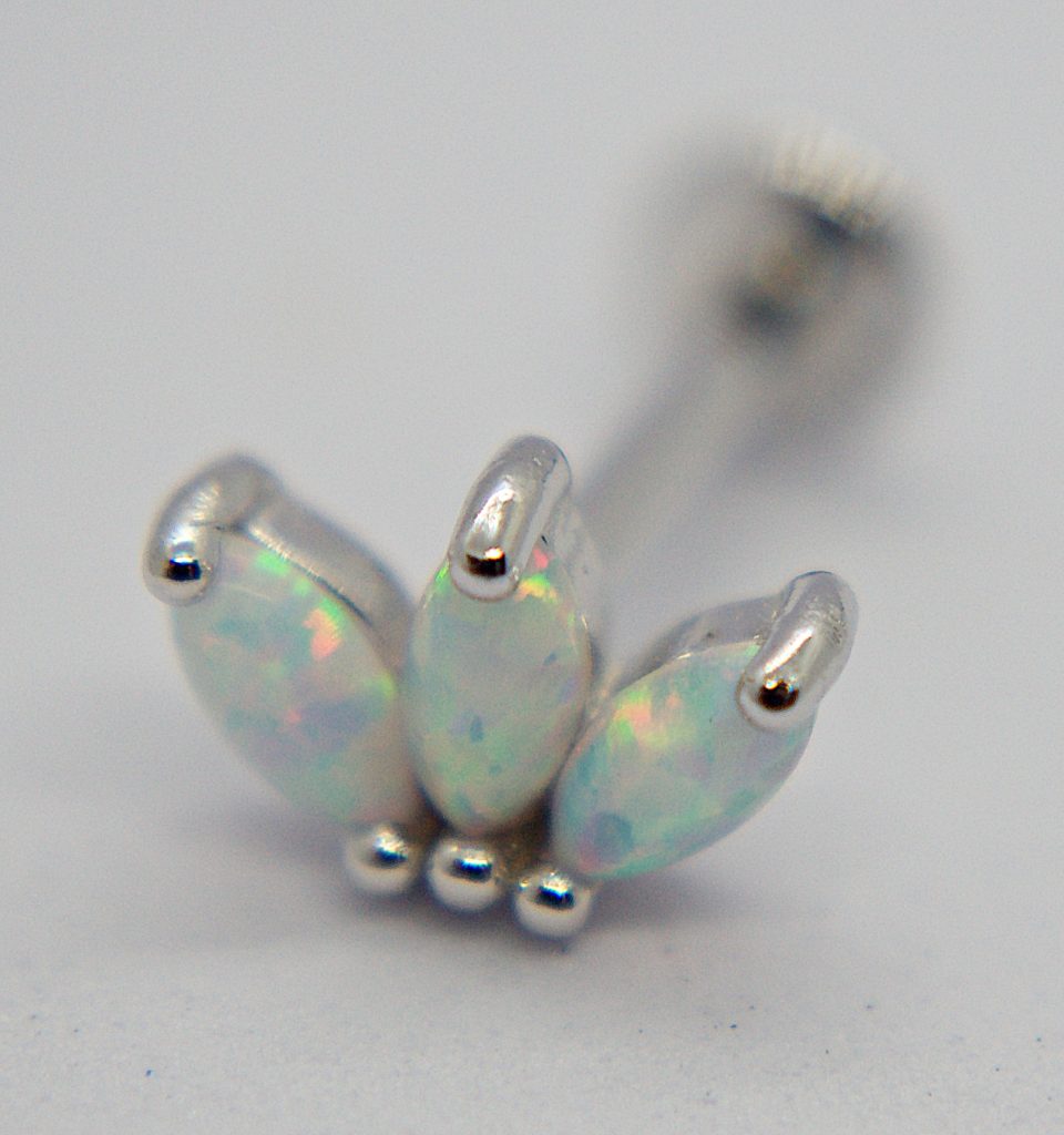 Close-up of a silver stud earring with three marquise opal stones arranged like a small crown and three silver bead accents.