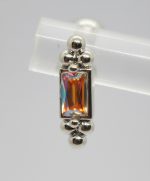 Silver earring with a vertical rectangular iridescent orange gemstone set between small polished silver bead clusters.