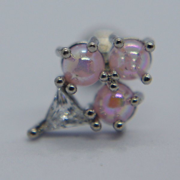 Small silver earring stud with three iridescent pink beads held by prongs and a small triangular clear gem on a pale background.