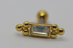 Gold stud earring with rectangular clear gemstone flanked by three small gold balls on each side, on white background.