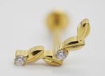Close-up of a small gold leaf-shaped ear stud set with two clear round gemstones on a white background.