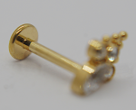 Close-up of a gold flat-back stud earring with a short post and a small cluster of clear gemstone settings.