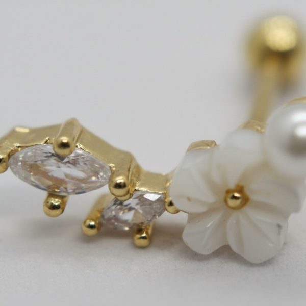 Gold ear barbell featuring two marquise clear stones, a carved white flower, and a small round pearl