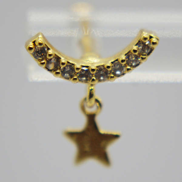 Gold earring stud with a curved row of small clear stones and a tiny dangling star charm on a soft gray background.