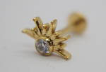 Gold-tone sunburst stud earring with round faceted clear stone at center, close-up with blurred screw-back