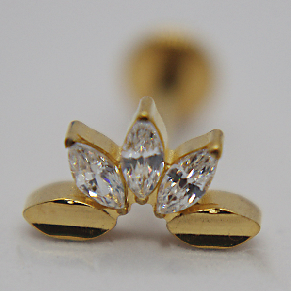 Gold stud earring with three marquise-cut clear stones arranged like a small crown, photographed in macro on a white surface.
