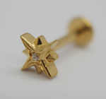 Gold star-shaped stud earring with a small clear center gem, close-up with blurred screw-back.