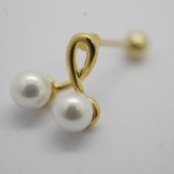 Gold earring stud with two white pearls joined by a small curved gold loop, lying on a soft white background.