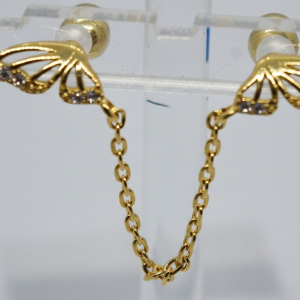 Pair of gold butterfly-wing studs with small clear rhinestones, linked by a short gold chain and displayed on a clear stand.