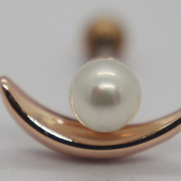 Round white pearl on a polished rose-gold crescent stud, shown in macro close-up on a plain background.