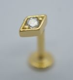 Gold labret stud earring with a diamond-shaped square bezel holding a round clear stone, on a short post with screw back.