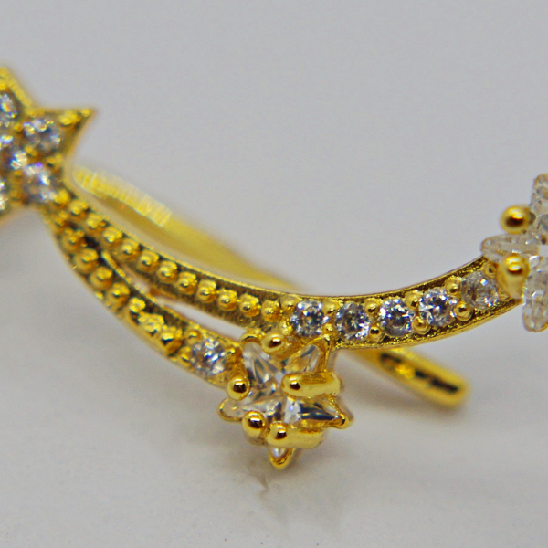 Gold-tone ear climber earring with two curved, gem-studded trails ending in three star-shaped crystal settings