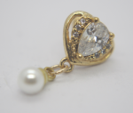 Gold heart pendant with a pear-shaped clear gemstone surrounded by small crystals and a dangling white pearl.