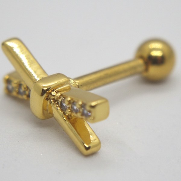 Gold cross-shaped barbell earring with small clear stones along the horizontal arm and a round screw-back ball on a pale background.