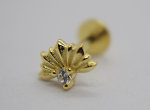 Gold shell-shaped stud earring with radiating ridges set with a small round clear gemstone, blurred backing behind.