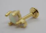 Gold labret stud with a small round opal held in four prongs and a stamped S925 backing, shown in macro on a white surface.