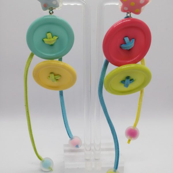 Pair of pastel dangle earrings with polka-dot star studs, stacked button discs and colorful cords ending in round beads.