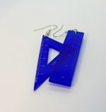 Two cobalt-blue translucent ruler earrings with silver hooks—a triangular ruler with center cutout and a rectangular ruler—lying on a white surface.