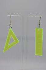 Neon yellow acrylic earrings: one triangular set square and one straight ruler, hanging from silver hooks on a clear stand.