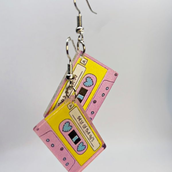Pink and yellow cassette-tape dangle earrings showing heart-shaped spools and label reading Best of the 90s.