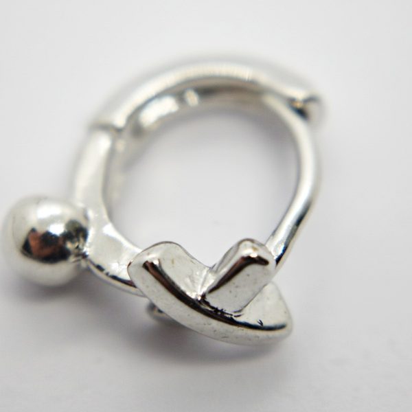 Close-up of a silver jewelry clasp: round loop with a bar toggle and a ball end on white background.