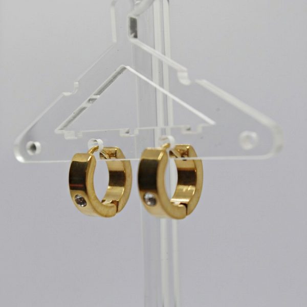 Pair of small gold huggie hoop earrings each set with a small clear stone, displayed on a clear acrylic earring hanger.