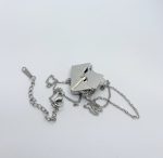 Silver necklace with envelope-style locket and circular rivet, tangled chain with lobster clasp on white background.