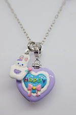 Silver chain with purple heart pendant showing a blue inner heart reading HAPPY, pink bow, and small white bunny charm.
