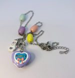 Silver chain necklace with pastel beads and a lavender heart locket reading HAPPY with a pink bow and a white bunny charm