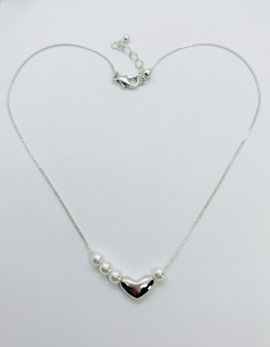 Delicate silver chain necklace shaped like a heart with a polished silver heart pendant flanked by white pearls and a lobster clasp