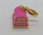 Small pink enamel mailbox keychain with gold trim and ring, decorative gold POST lettering on the front.