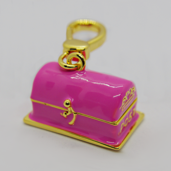 Small pink enamel treasure-chest keychain with gold trim, latch, and lobster-claw clasp.