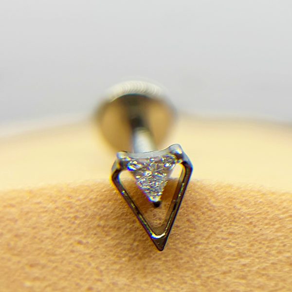 Close-up of a triangular diamond nose stud piercing in skin