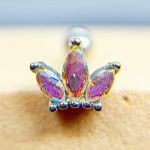 Colourful jeweled nose stud with three purple teardrop stones in a gold setting attached to skin