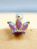 Colourful jeweled nose stud with three purple teardrop stones in a gold setting attached to skin