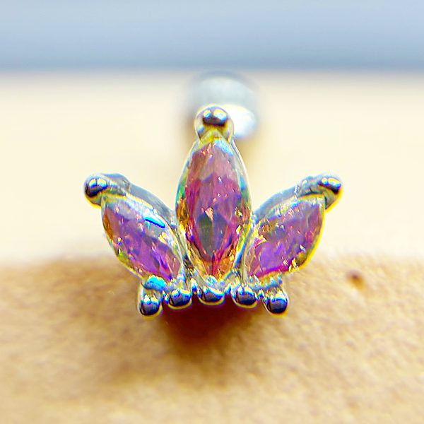 Colourful jeweled nose stud with three purple teardrop stones in a gold setting attached to skin