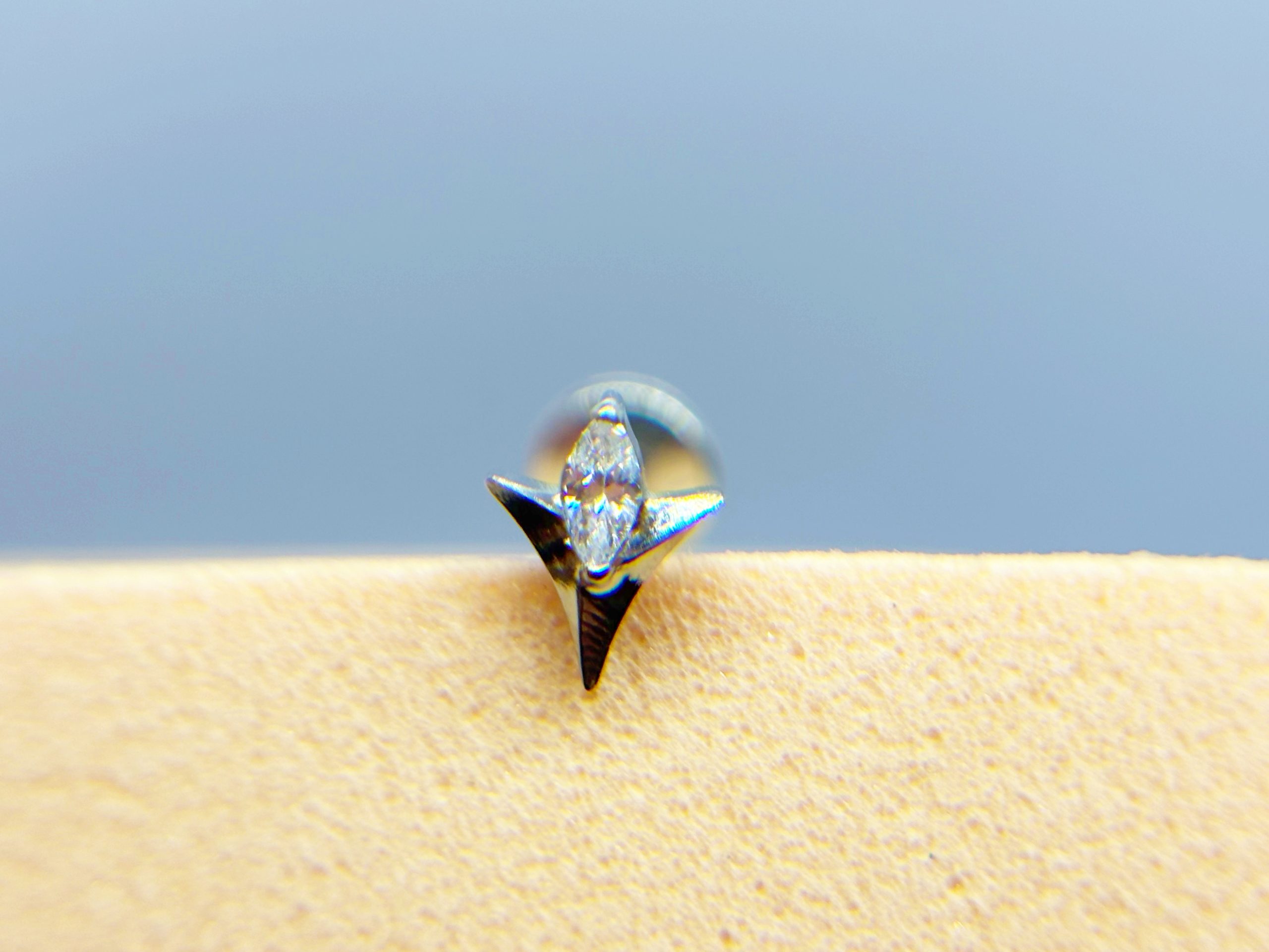 Close-up of a sparkling diamond stud earring on skin