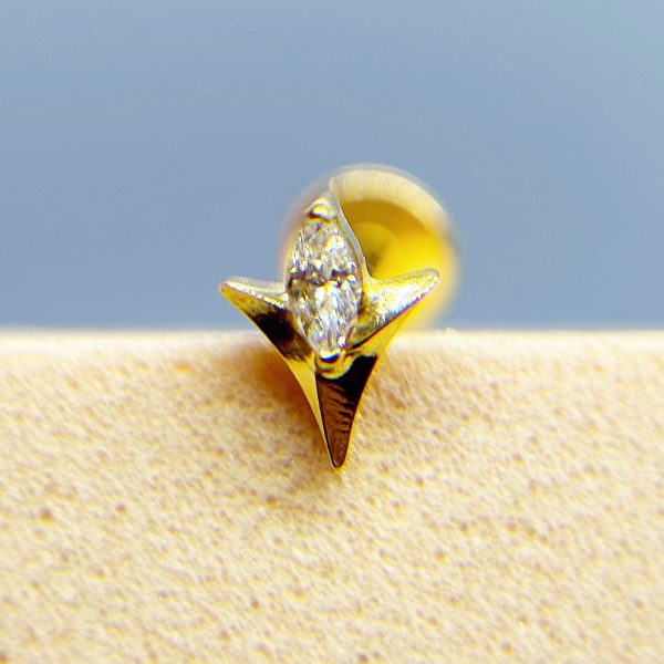 Close-up of a diamond set in a gold ring against a soft blue background