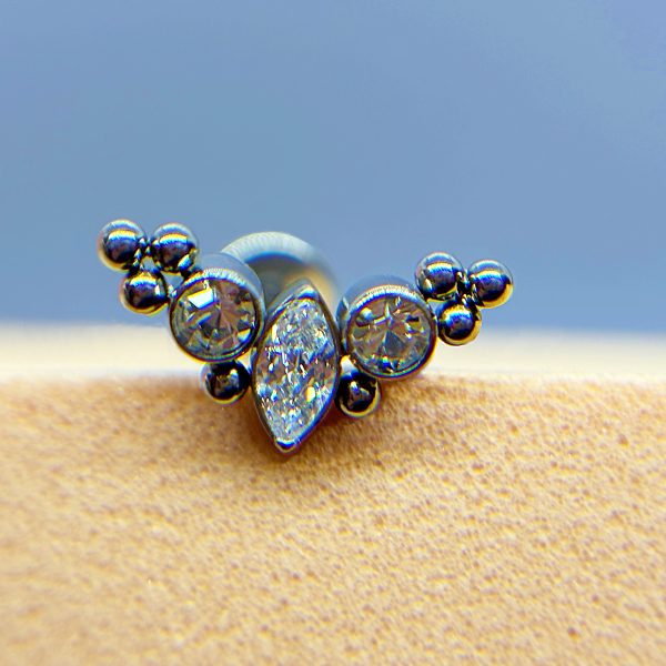 Close-up of a silver crystal and bead ring against a blurred blue and beige background